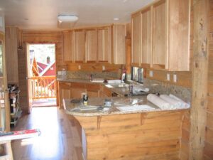 Wooden kitchen interior with granite countertop.