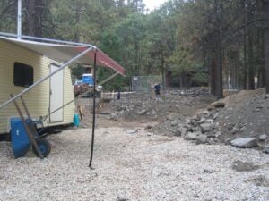 Caravan near construction site in forested area.