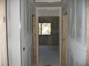 Interior construction site, unfinished drywall, and doorway.