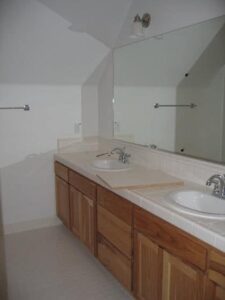 Dual-sink bathroom vanity with wooden cabinets.