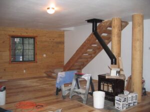 Interior cabin renovation in progress with wood stove.