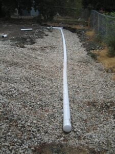 PVC pipe laid on gravel for construction drainage.