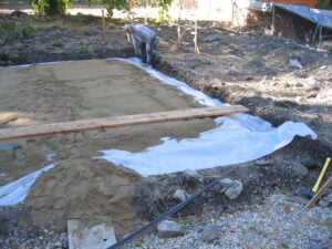 Person leveling groundwork for construction site.