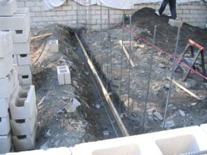 Foundation excavation at construction site with rebar installation.