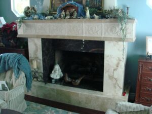 Decorated fireplace with nativity scene and cozy throw blanket.