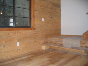 Wood-paneled room with staircase and large window.