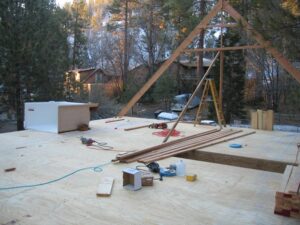 Residential construction site with wooden framing and tools.