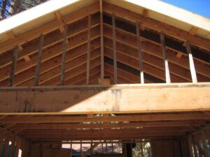 Wooden house frame under construction with exposed beams.