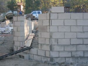 Cinder block wall under construction at building site.