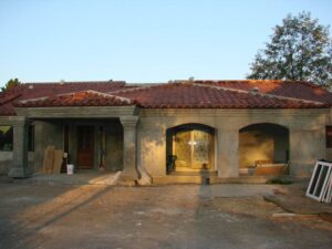 House under construction with terracotta roof tiles.