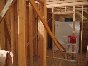Wooden house frame under construction with tools.