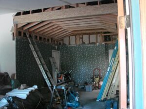Interior home renovation, exposed rafters and construction tools.