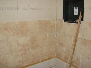 Incomplete bathroom tiling project with moisture protection.