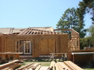 Wooden house frame construction site on a sunny day.