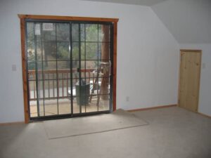 Empty room with large window and balcony door.