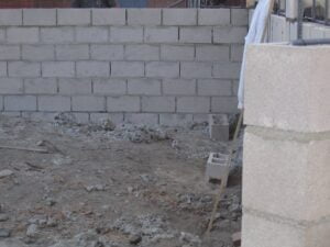 Construction site with unfinished cinder block wall.