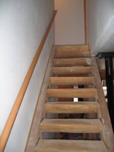 Wooden staircase with handrail in home.