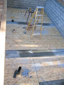 Construction site with tools and ladder on floor.