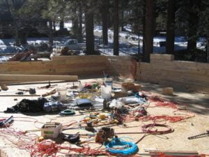 Construction site with tools and lumber outdoors.