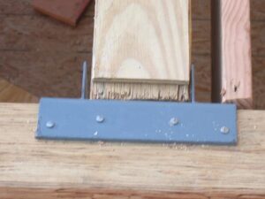 Metal bracket securing wooden plank construction detail.
