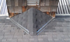 Roof valley flashing and shingles repair on house.