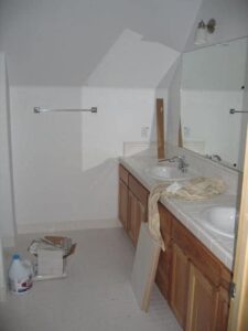 Unfinished bathroom interior with double sink and mirror.